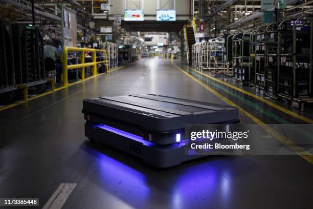 Mobile Industrial Robots automated guided vehicle moves along the Camry sedan assembly line at the Toyota Motor Corp. Manufacturing plant in...