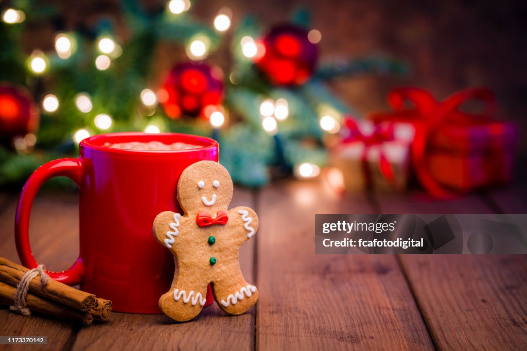 Taza casera de chocolate caliente y galleta de pan de jengibre en la mesa de Navidad