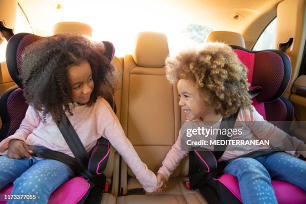 ethnic sister girls car back seat with belts - child car seat stock pictures, royalty-free photos & images