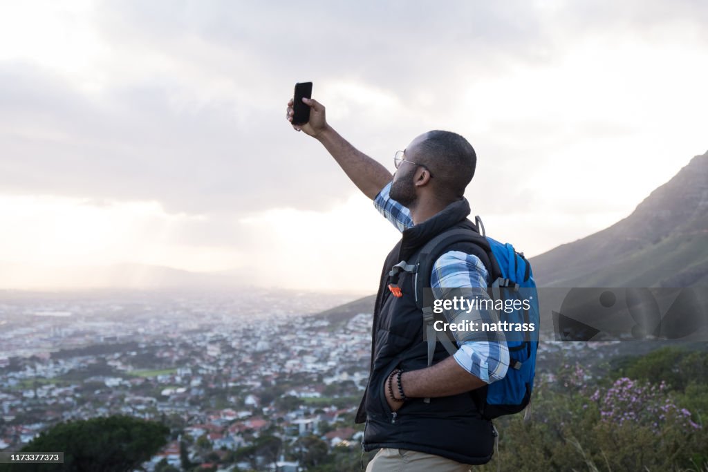 Man taking selfie while standing on Table Mountain