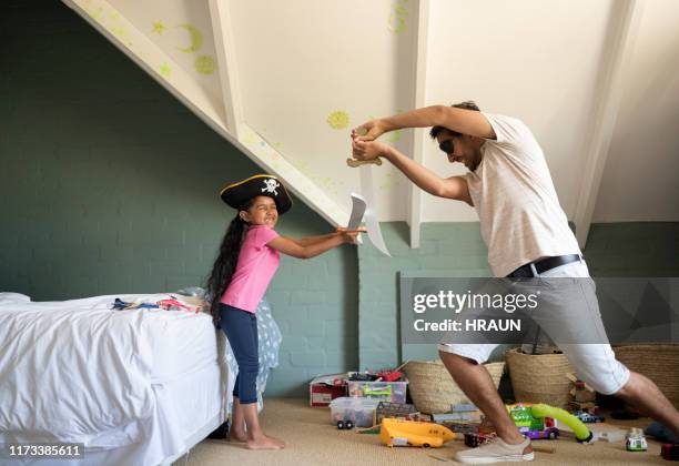 father and daughter sword fighting in playroom - sword fight stock pictures, royalty-free photos & images