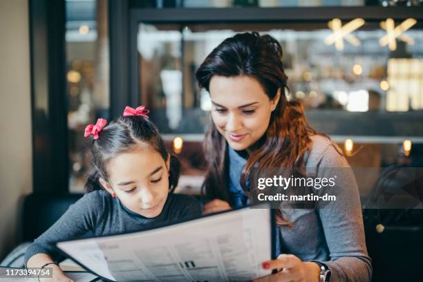 mother and daughter in restaurant - menu stock pictures, royalty-free photos & images