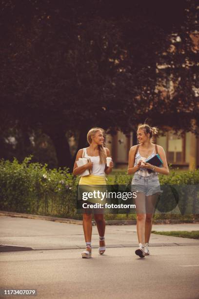 giovani donne che passeggiano fuori e sorridono - summer university day 2 foto e immagini stock