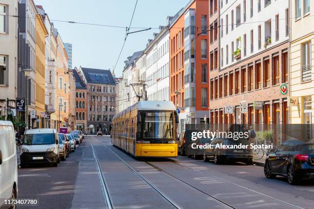 street with yellow cable car on a sunny day, berlin, germany - berlin straße stock-fotos und bilder