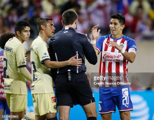 Paul Aguilar of Club America and Jesus Molina of Chivas de Guadalajara make their cases with the referee during the Super Clasico game at Soldier...