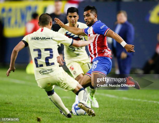 Miguel Ponce of Chivas de Guadalajara gets to the ball ahead of Paul Aguilar of Club America during the Super Clasico game at Soldier Field on...