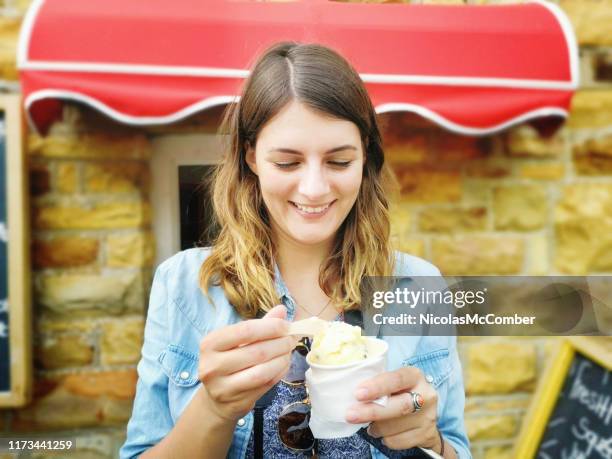 hermosa joven disfrutando de un helado de helado congelado en una taza - ice cream cup fotografías e imágenes de stock