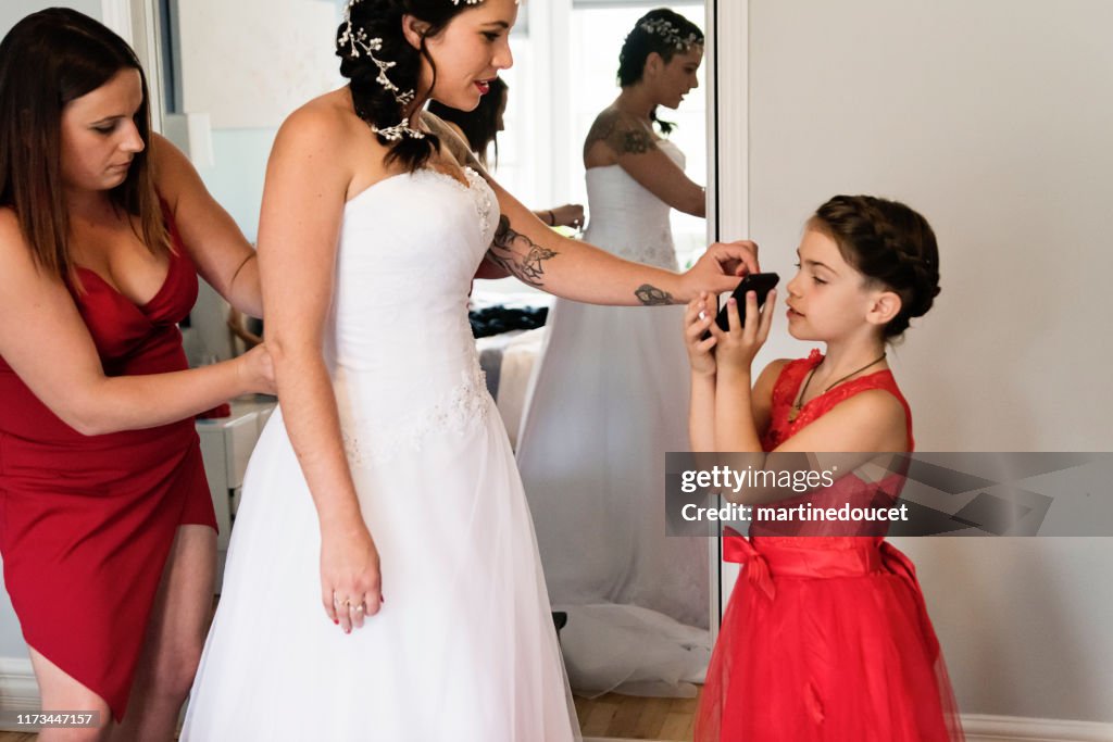 Millenial kvinna sätta på hennes bröllopsklänning.