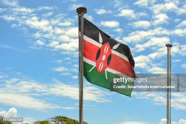 kenyan flag waving against blue sky in mombasa, kenya - kenyan flag fotografías e imágenes de stock