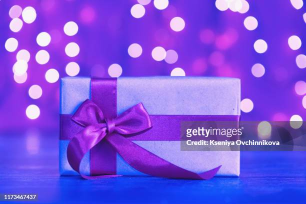 gift box in vibrant bold gradient holographic colors. christmas concept art. minimal new year surrealism. - ultraviolett stock-fotos und bilder