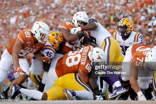 Keaontay Ingram of the Texas Longhorns is stopped short of the goal line by Michael Divinity Jr. #45 of the LSU Tigers and Patrick Queen in the first...