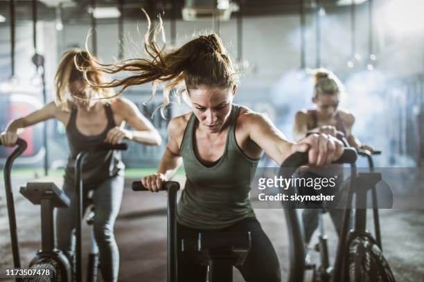gruppo di donne atletiche in cyclette in un centro sanitario. - pinning foto e immagini stock