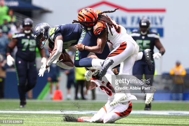 Metcalf of the Seattle Seahawks completes a pass against Jessie Bates and B.W. Webb of the Cincinnati Bengals in the third quarter during their game...