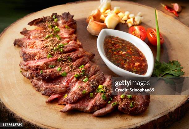 beef steak with herbs and spices on a cutting board with tasty sauce which is popular in asian people - brotzeitbrett stock-fotos und bilder