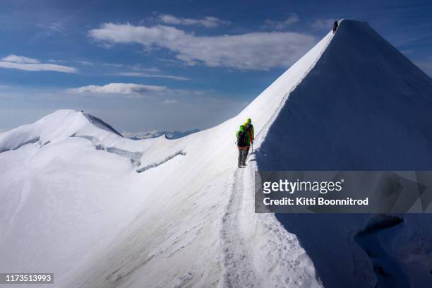 mountaineers climbing to the summit ridge of castor, switzerland - mountain ridge stock-fotos und bilder