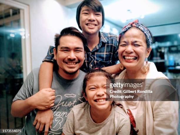 family of four smiling at camera - philippines family imagens e fotografias de stock