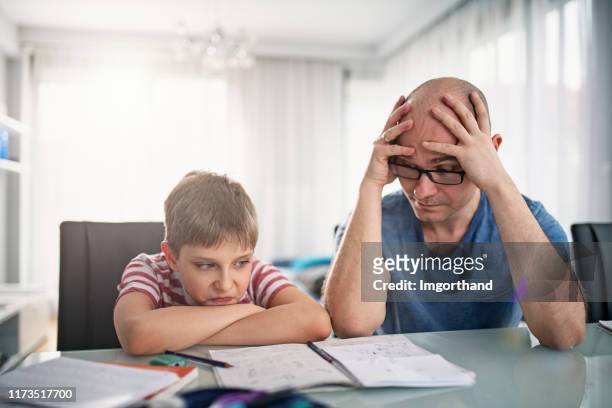 father and son having trouble with homework - homework frustration stock pictures, royalty-free photos & images
