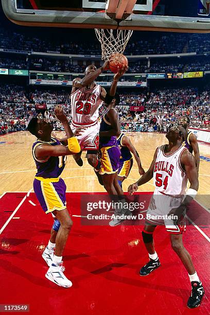 Michael Jordan of the Chicago Bulls drives and moves the basketball to his left hand in mid-air against the Los Angeles Lakers during Game two of the...