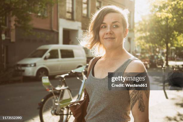 tattooed woman on the street in the city - city gegenlicht stock-fotos und bilder