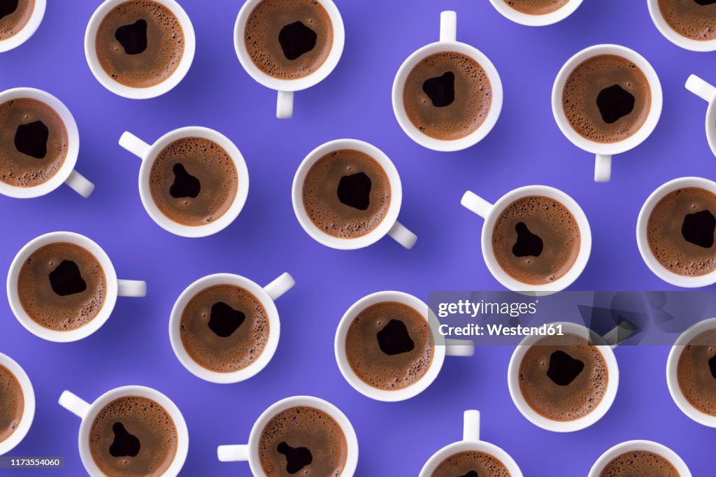 Directly above view of fresh coffee in cups over purple background