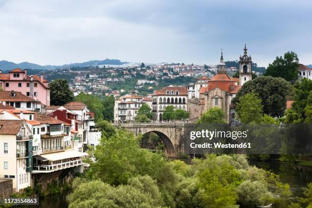 bridge amidst buildings in town at duoro valley against cloudy sky - duoro valley stock pictures, royalty-free photos & images