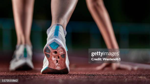 legs of female athlete running on tartan track - linea di partenza attrezzatura sportiva foto e immagini stock