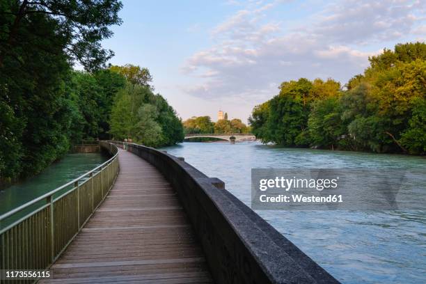 germany, upper bavaria, munich, boardwalk on isar river with kabelsteg bridge and deutsches museum in background - río isar fotografías e imágenes de stock