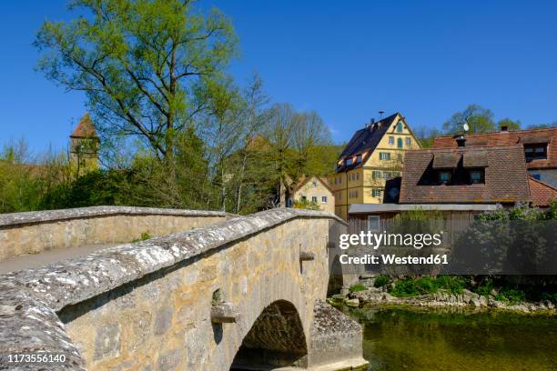 old arch bridge over tauber river with town houses in background, rothenburg ob der tauber, bavaria, germany - rothenburg stock pictures, royalty-free photos & images