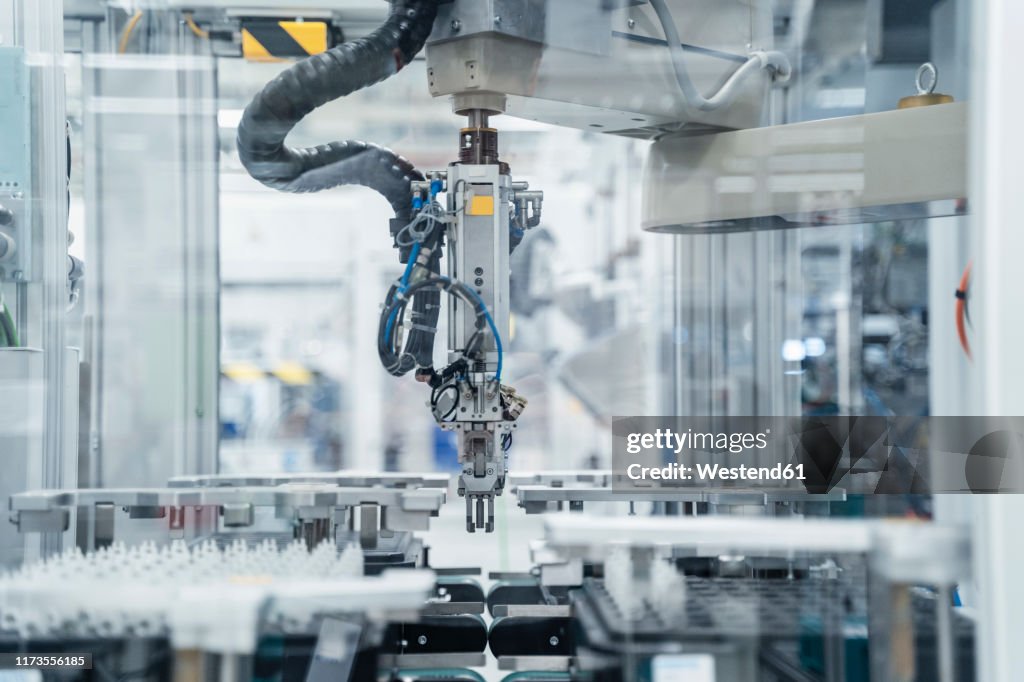 Arm of assembly robot functioning inside modern factory, Stuttgart, Germany