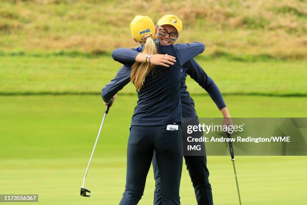 Hannah Darling and Annabell Fuller of Team Europe embrace after winning the match on the 15th green during the PING Junior Solheim Cup during...