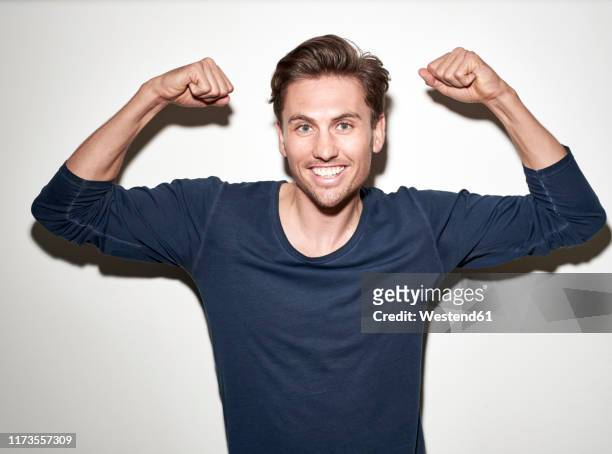 portrait of laughing man flexing muscles - puño manga fotografías e imágenes de stock