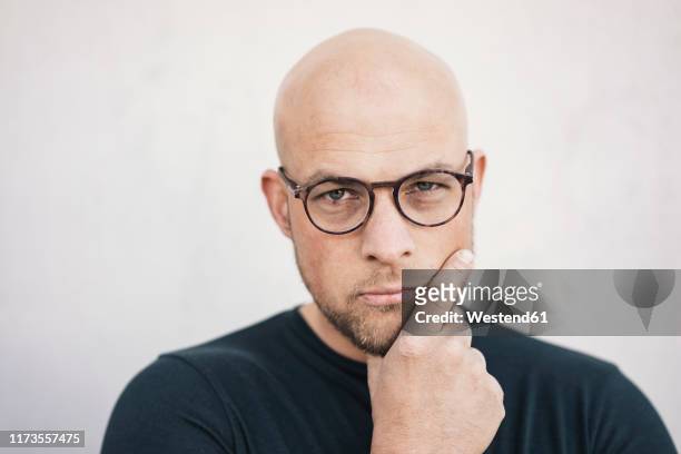 portrait of starring bald man wearing glasses - suspicion stock-fotos und bilder