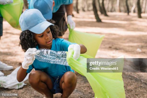 group of volunteering children collecting garbage in a park - guía scout fotografías e imágenes de stock