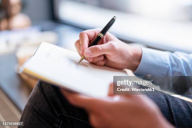 close-up of businessman taking notes in office - biro stock-fotos und bilder