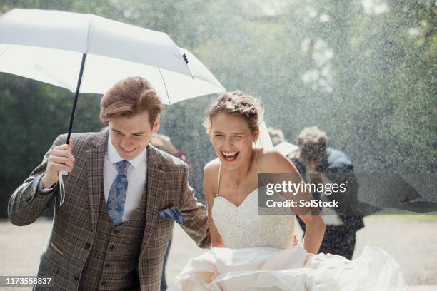 running through the rain - wedding umbrella stock pictures, royalty-free photos & images