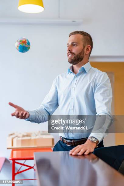 businessman throwing up miniature globe in office - shirt mockup stock pictures, royalty-free photos & images