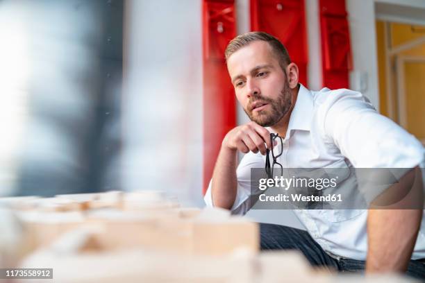 businessman looking at architectural model in office - un seul homme d'âge moyen photos et images de collection