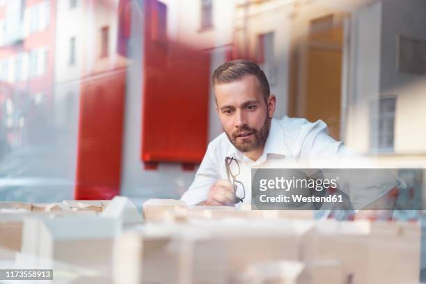 businessman looking at architectural model in office - shirt mockup stock pictures, royalty-free photos & images