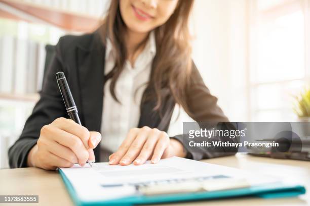 hand of businesswoman writing on paper in office - deal signing stock pictures, royalty-free photos & images