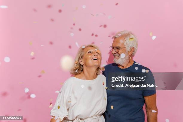 lachend senior paar viert hun verjaardag - senioren koppel studio stockfoto's en -beelden