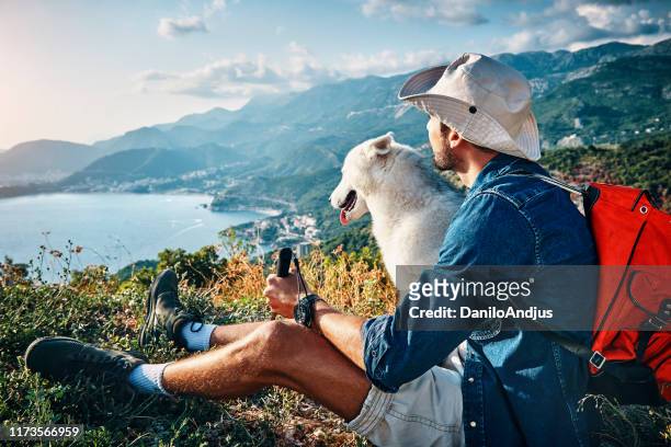 hombre su mejor amigo tomando un descanso de senderismo - montenegro fotografías e imágenes de stock