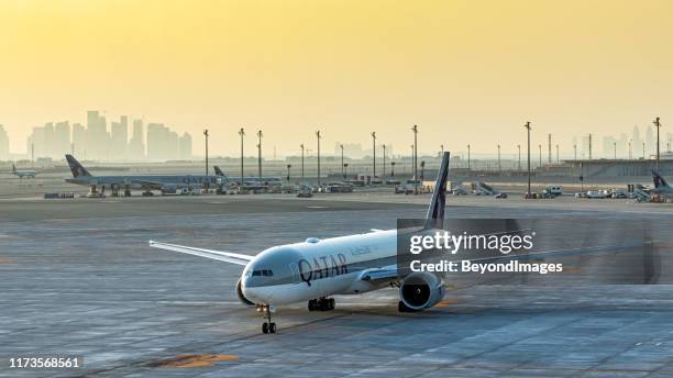 qatar airways boeing plane arrives at doha airport at sunset on hot summer day - doha airport stock pictures, royalty-free photos & images