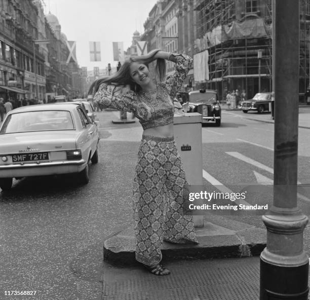 Female fashion model wearing long sleeves crop top and high-waist flared pants in 'harem' style on Regent Street, London, UK, 28th May 1970.