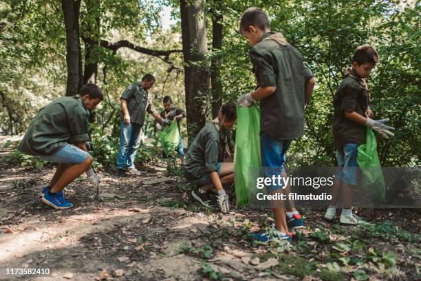 scouts schoonmaken lokaal bos - boy scout camping stockfoto's en -beelden