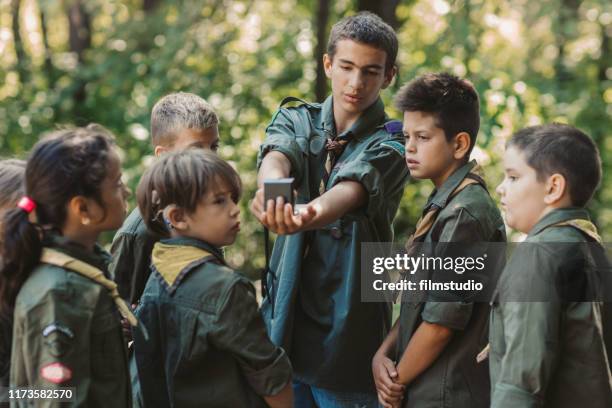 15 years old boy scout teaching boys and girls how to use compass - girl scout camp stock pictures, royalty-free photos & images