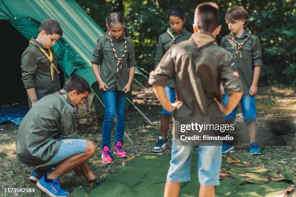 gruppe von pfadfindern baut ein zelt - pfadfinder stock-fotos und bilder