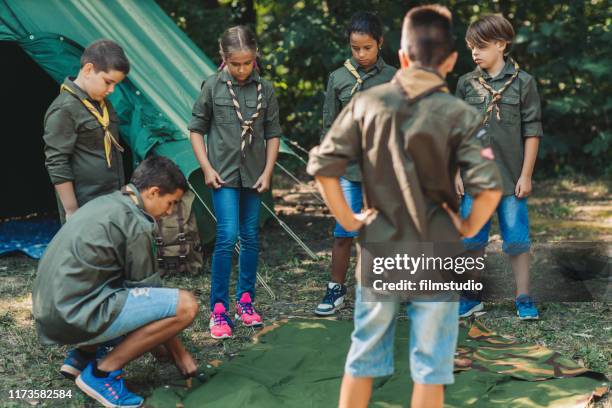 group of scouts building a tent - boy scouts stock pictures, royalty-free photos & images