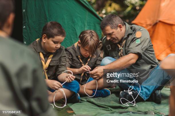 scouterna lär sig knyta knuten - pojkscout bildbanksfoton och bilder