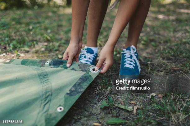 scouts making camouflage raincoat - boy scout camping stock pictures, royalty-free photos & images