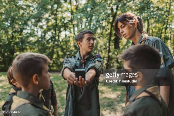 15 jaar oude jongen scout onderwijs jongens en meisjes hoe kompas te gebruiken - boy scout camp stockfoto's en -beelden